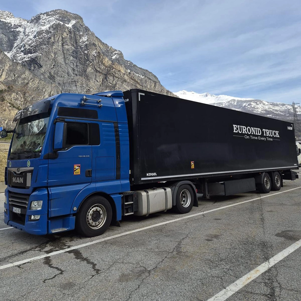 Camion MAN albastru si semiremorca box fotografiate in parcare la o pauza binemeritata